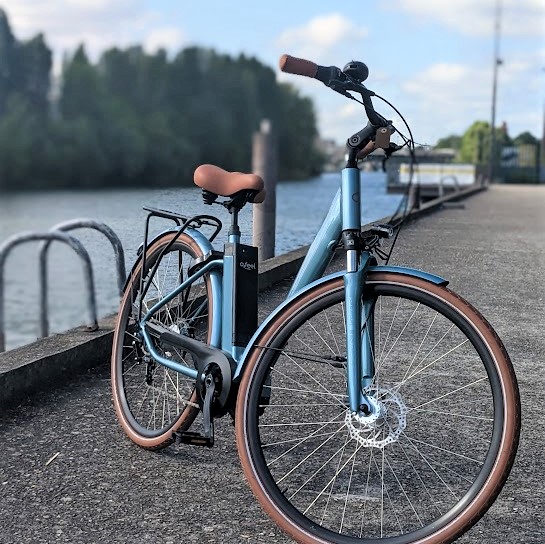 Photo d'un vélo électrique O2Feel sur un quai devant la Seine à Courbevoie.