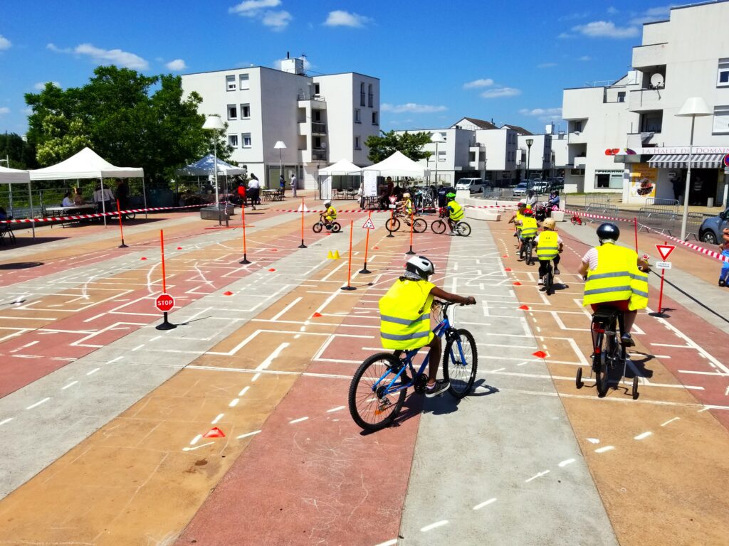 Photo vue large d'un parcours de sécurité routière parcouru par un groupe d'une dizaine d'enfants.