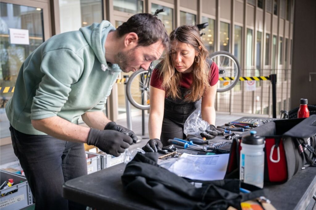 Photo de deux mécaniciens devant une table d'outils lors d'un atelier mobile.
