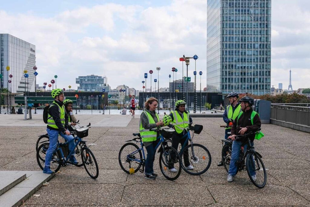 Groupe de cyclistes en formation vélo entreprise dans le cadre d'un parcours urbain encadré.
