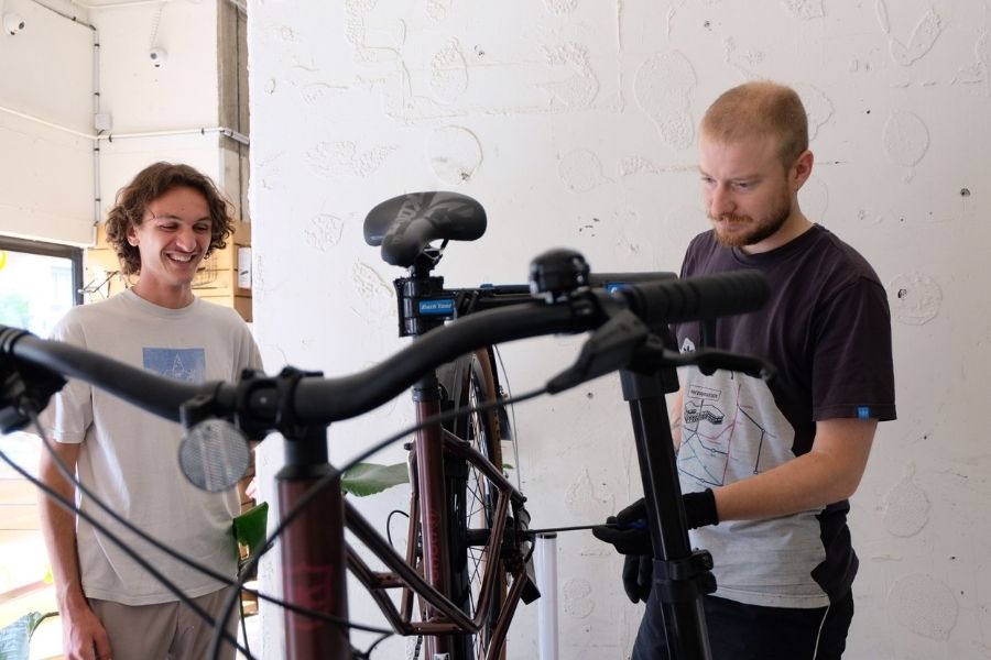 Une réparation vélo à Levallois-Perret effectuée par un mecanicien avec un client derriere