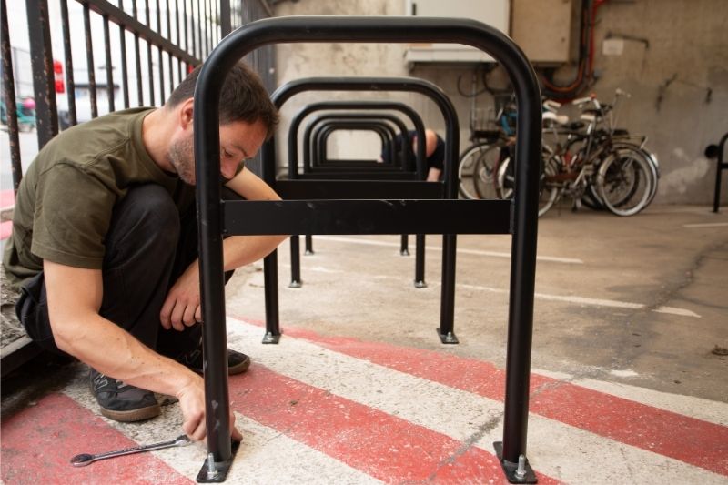 Artisan qui installe des arceaux vélos dans une copropriété pour un local vélo obligatoire.